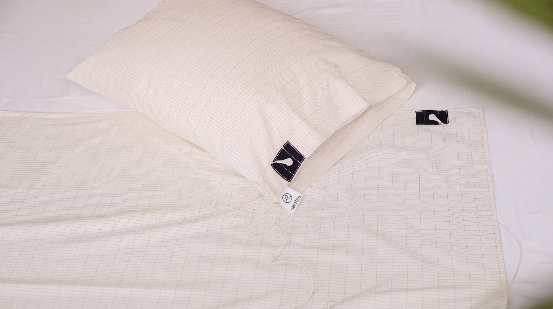 Drap et taie d'oreiller de mise à la terre, avec le quadrillage des fils d'argent, sur un lit fait