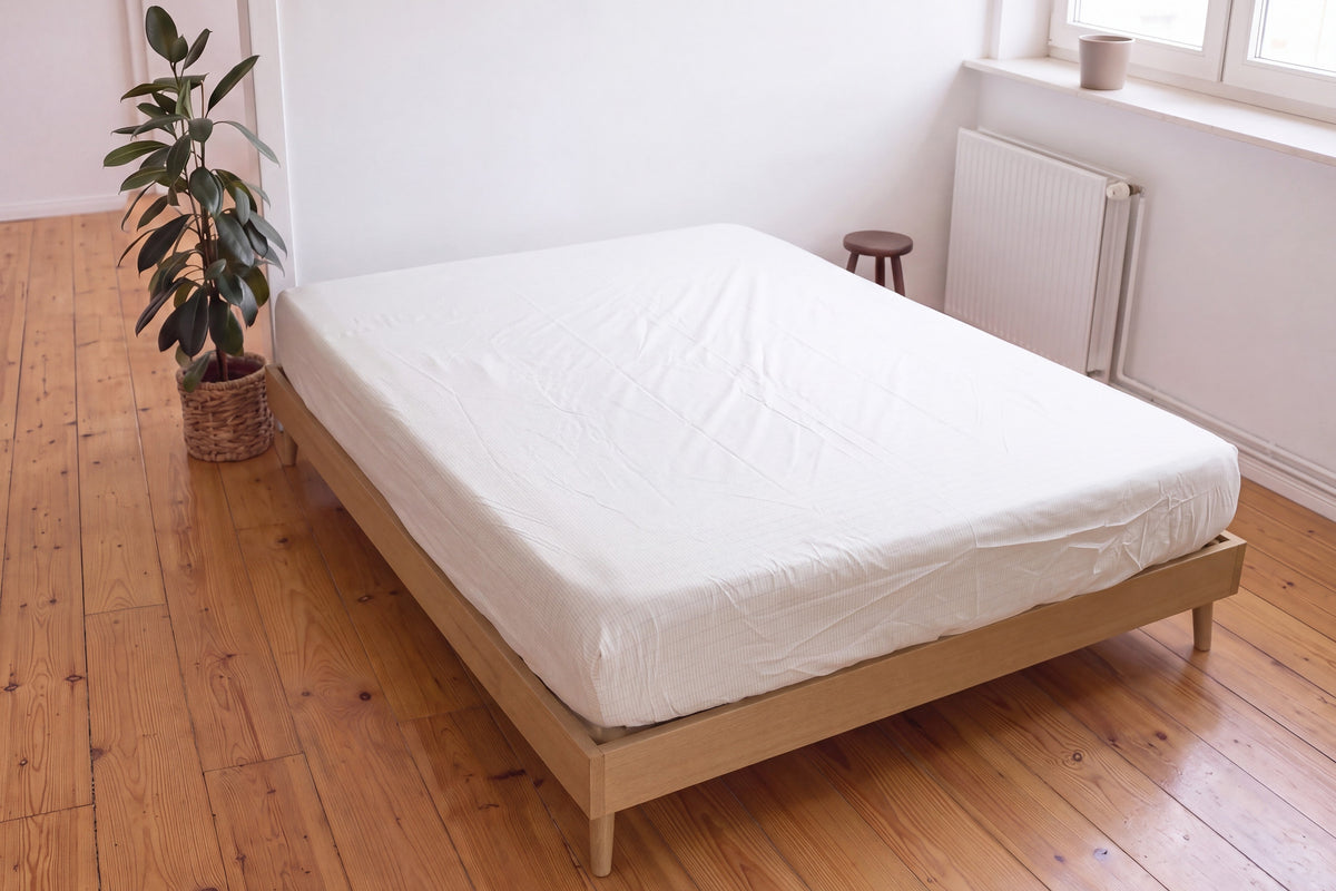 Earthle aardingshoeslaken op een tweepersoonsbed in een lichte slaapkamer