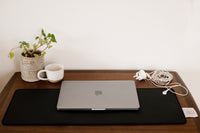Tapis de bureau Earthle avec ordinateur portable, plante et mug, le câble relié à la prise