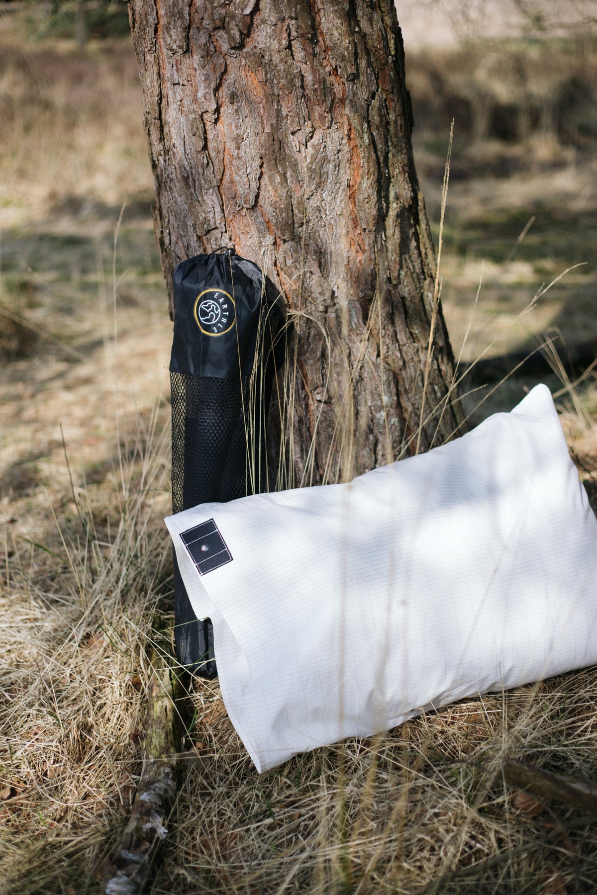 Taie d'oreiller de mise à la terre Earthle avec sa housse contre un tronc de pin en forêt