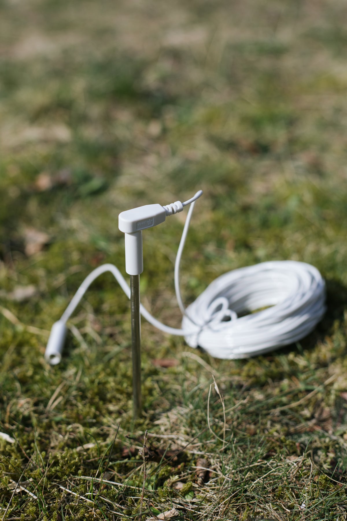Earthle aardingspin in de volle grond, met de opgerolde kabel ernaast
