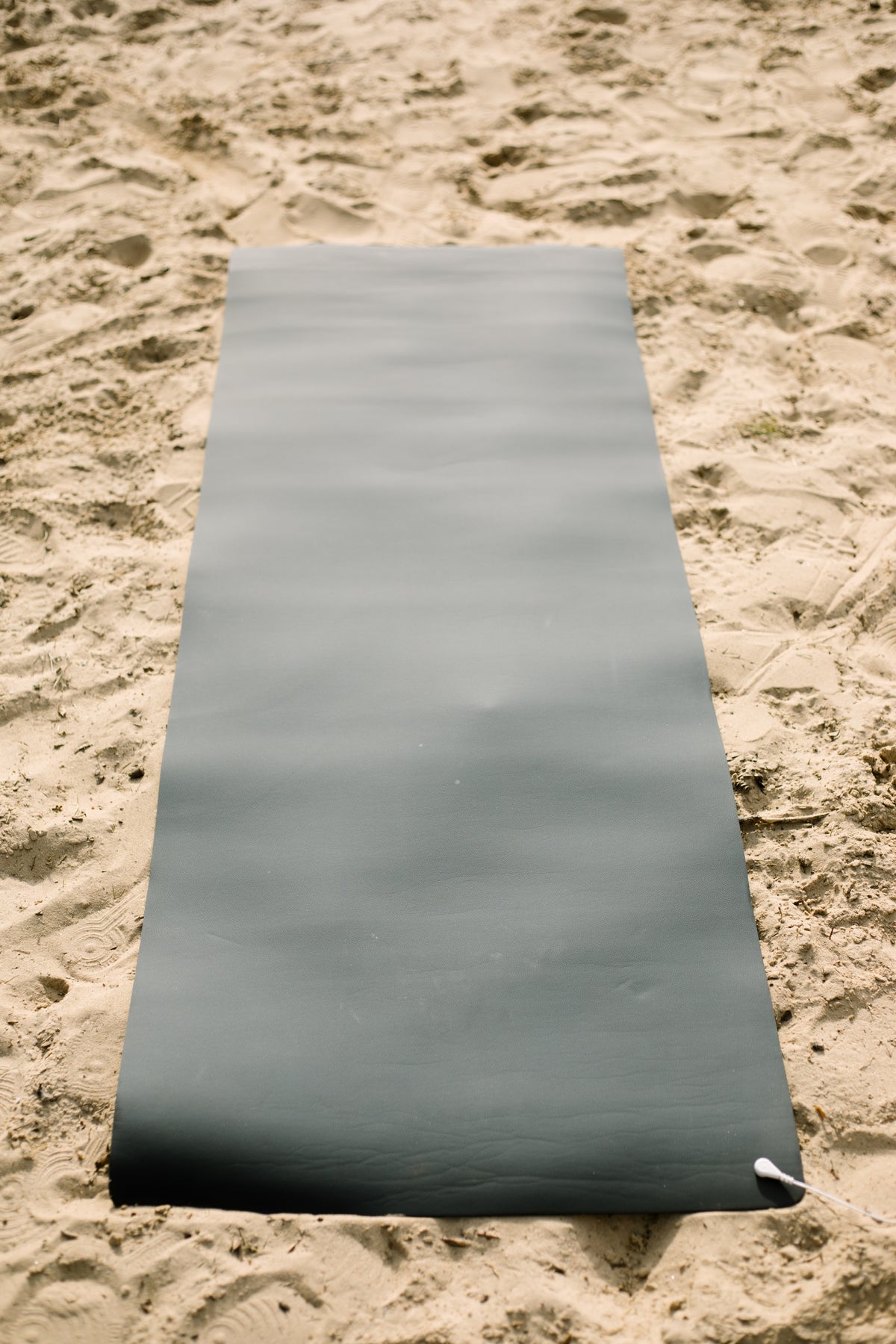 Tapis de yoga de mise à la terre Earthle déroulé sur le sable