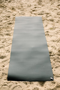 Tapis de yoga de mise à la terre Earthle déroulé sur le sable