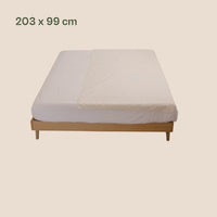 Earthle aardingslaken over een matras op een houten bed, 203 x 99 cm